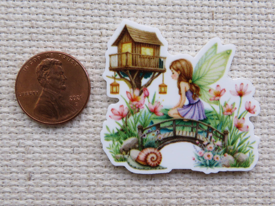 Minder of a fairy sitting on a bridge with flowers and a treehouse in the background